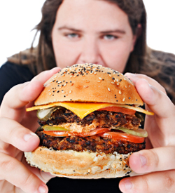 Overweight teen eating unhealthy meal