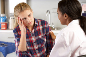 Teenage Girl Visits Doctor's Office Suffering With Depression