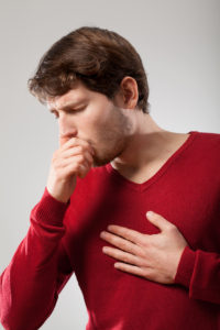 Man with sick lungs holding his chest and coughing